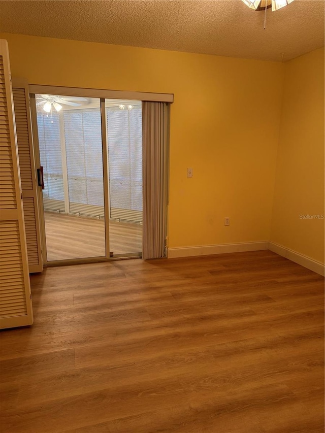 unfurnished room with a textured ceiling, ceiling fan, and hardwood / wood-style floors