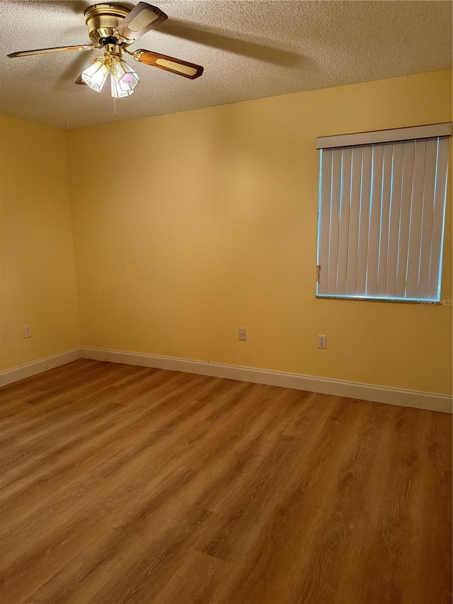 spare room featuring a textured ceiling, ceiling fan, and hardwood / wood-style floors