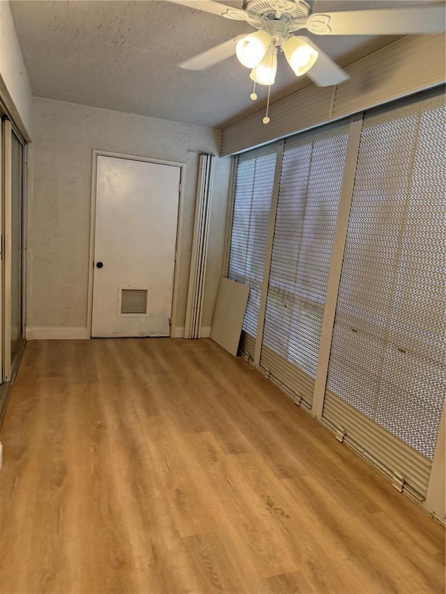 unfurnished bedroom featuring ceiling fan, a textured ceiling, and light hardwood / wood-style flooring