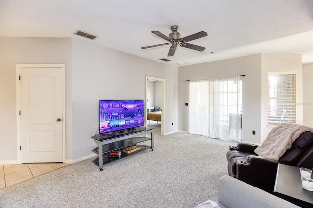 carpeted living room featuring ceiling fan and a textured ceiling