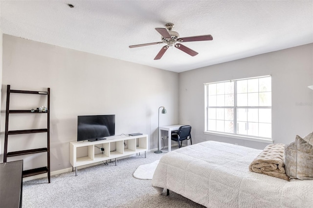 bedroom with ceiling fan, light colored carpet, and a textured ceiling