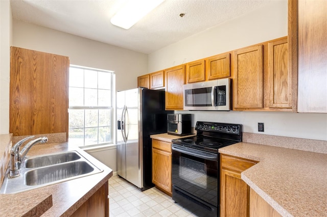 kitchen featuring appliances with stainless steel finishes, sink, and a textured ceiling