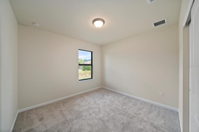 carpeted empty room with a textured ceiling