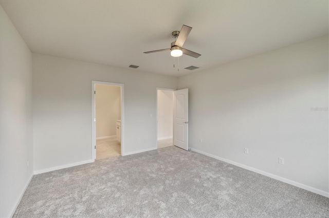 unfurnished bedroom featuring connected bathroom, ceiling fan, and light colored carpet