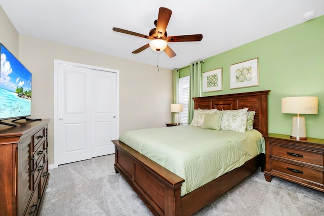 carpeted bedroom with ceiling fan and a closet