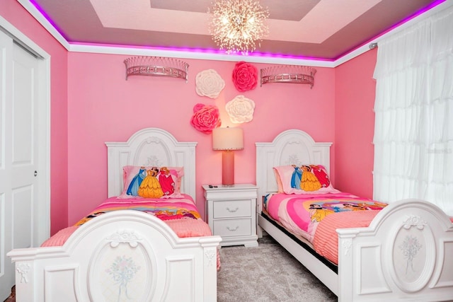 carpeted bedroom featuring a notable chandelier and a raised ceiling