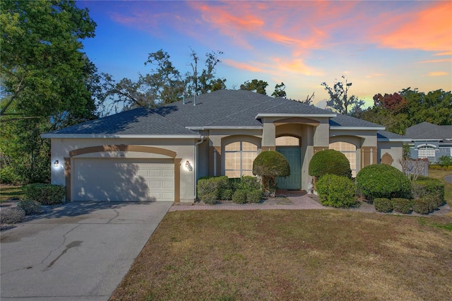 single story home with a garage and a yard