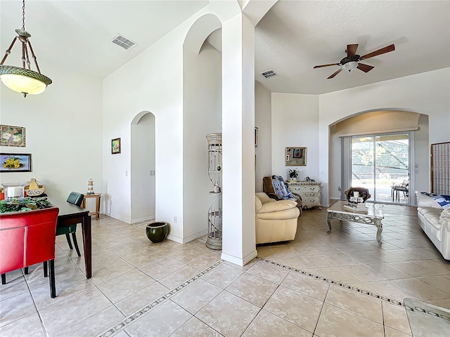 tiled living room featuring ceiling fan and a textured ceiling