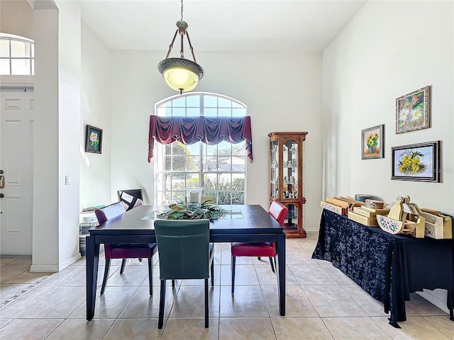 dining space with light tile patterned flooring and a high ceiling