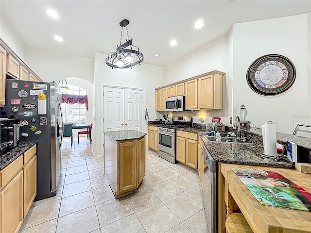 kitchen with hanging light fixtures, sink, stainless steel appliances, and light tile patterned flooring