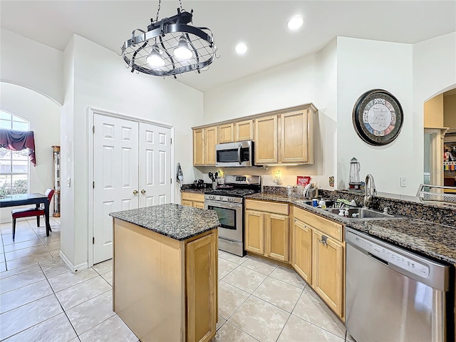 kitchen with stainless steel appliances, sink, hanging light fixtures, kitchen peninsula, and light tile patterned flooring