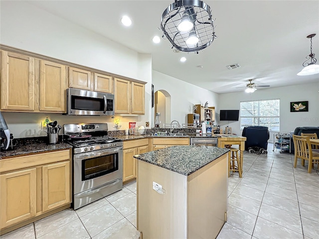 kitchen featuring appliances with stainless steel finishes, decorative light fixtures, light brown cabinets, sink, and light tile patterned floors