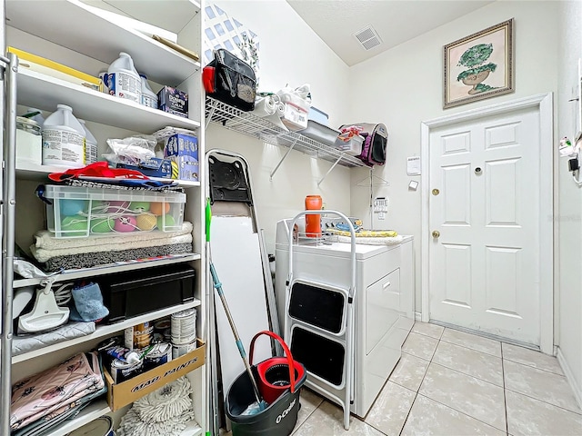 clothes washing area featuring light tile patterned flooring and washing machine and clothes dryer