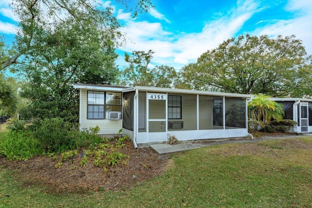 view of front of house featuring a front lawn and a sunroom