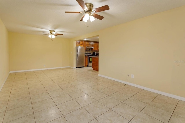 tiled empty room with ceiling fan and a textured ceiling