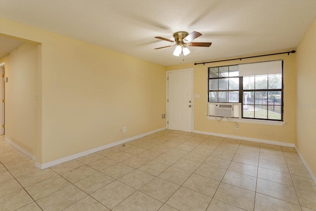 tiled empty room with ceiling fan, cooling unit, and a textured ceiling