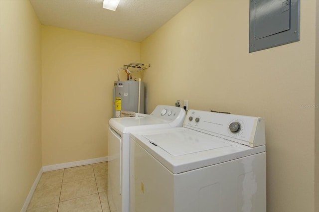 washroom with light tile patterned floors, electric water heater, washer and dryer, a textured ceiling, and electric panel