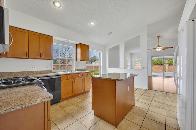 kitchen featuring a kitchen island, black dishwasher, white refrigerator, ceiling fan, and light tile patterned floors