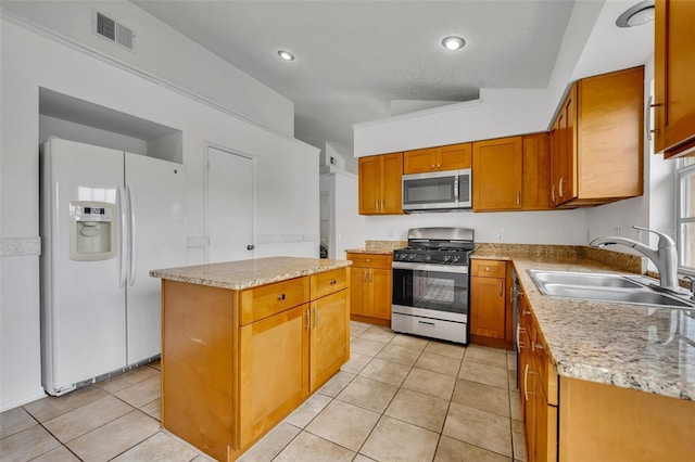 kitchen with sink, appliances with stainless steel finishes, a center island, and light tile patterned flooring