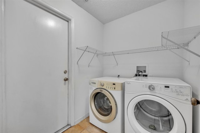 laundry area with light tile patterned flooring, separate washer and dryer, and a textured ceiling