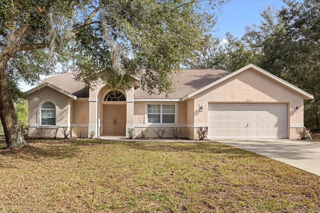 ranch-style house with a garage and a front yard