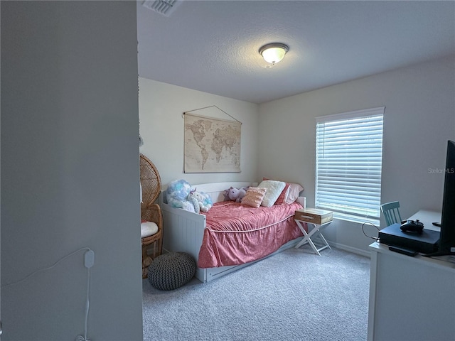 bedroom with carpet floors and a textured ceiling