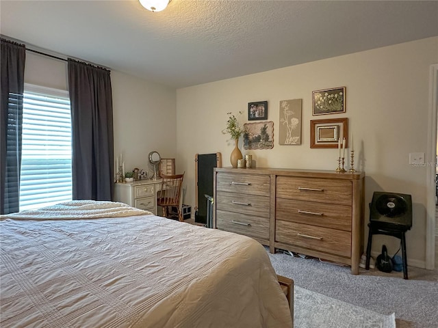 bedroom with a textured ceiling and light colored carpet