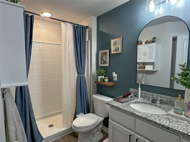 bathroom featuring a textured ceiling, hardwood / wood-style floors, vanity, a shower with curtain, and toilet