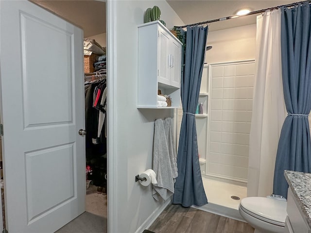 bathroom with hardwood / wood-style flooring, curtained shower, and toilet