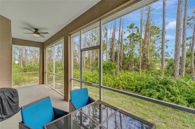 unfurnished sunroom with ceiling fan