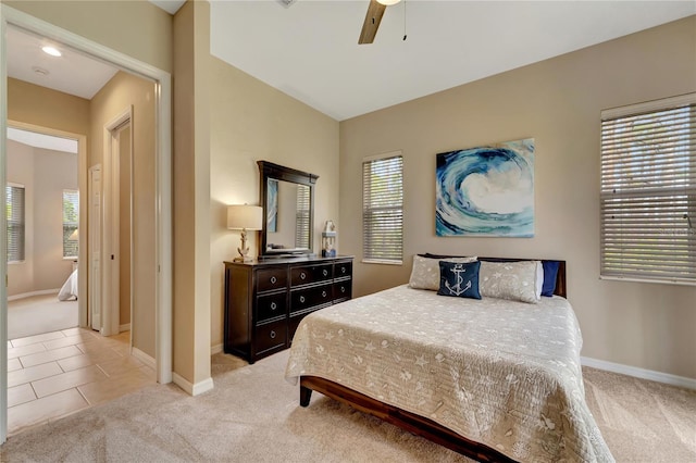 bedroom featuring ceiling fan, light colored carpet, and multiple windows