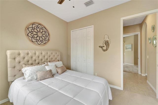 bedroom with light carpet, ceiling fan, and a closet