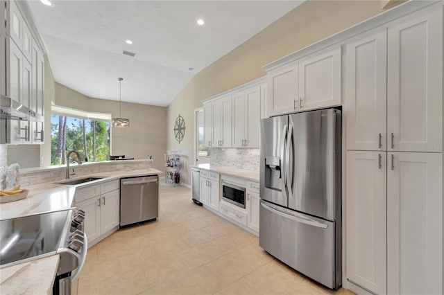 kitchen featuring appliances with stainless steel finishes, decorative light fixtures, white cabinetry, sink, and vaulted ceiling