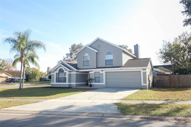 front facade featuring a garage, a front yard, and central AC unit