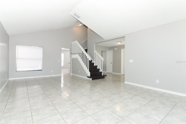 tiled spare room with vaulted ceiling