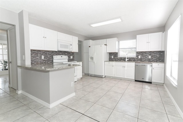 kitchen featuring white appliances, white cabinetry, sink, kitchen peninsula, and light tile patterned flooring