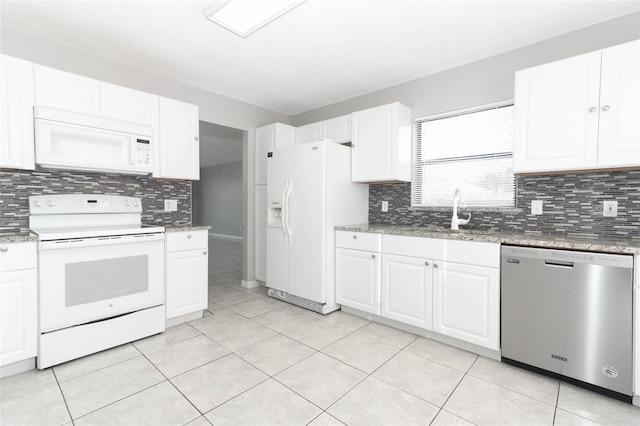 kitchen featuring white appliances, tasteful backsplash, white cabinetry, light tile patterned floors, and sink