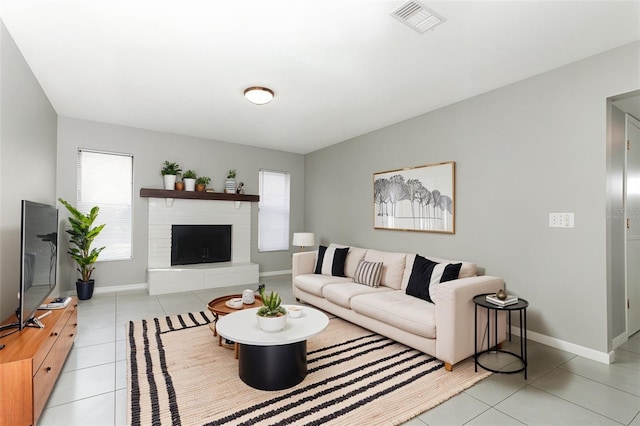 living room with plenty of natural light, light tile patterned floors, and a fireplace