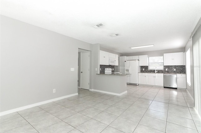 kitchen with white cabinetry, white appliances, light tile patterned floors, and kitchen peninsula