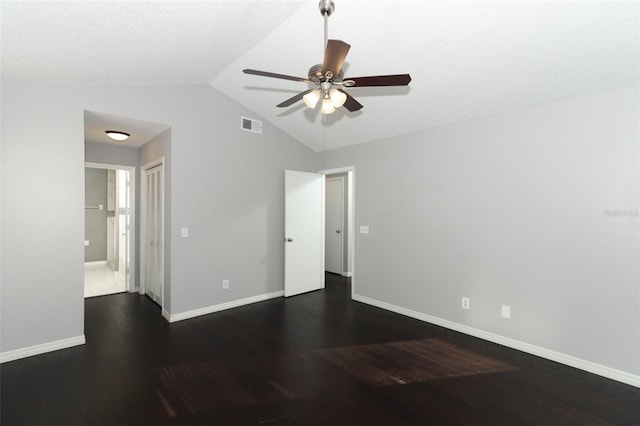 empty room with vaulted ceiling, ceiling fan, and dark wood-type flooring