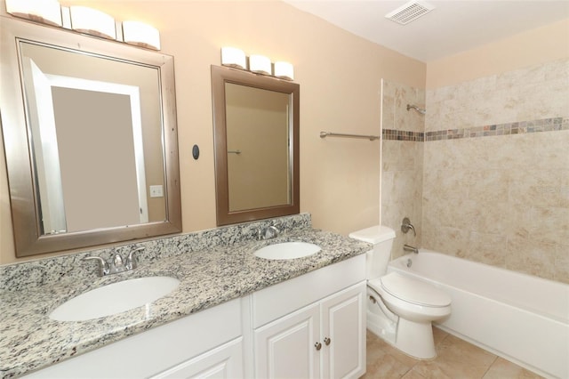 full bathroom featuring tiled shower / bath combo, vanity, toilet, and tile patterned flooring