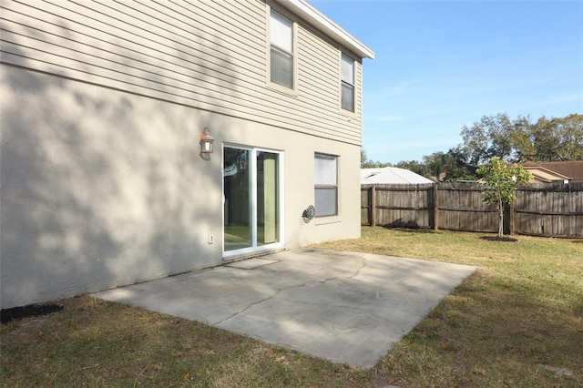 rear view of property with a lawn and a patio