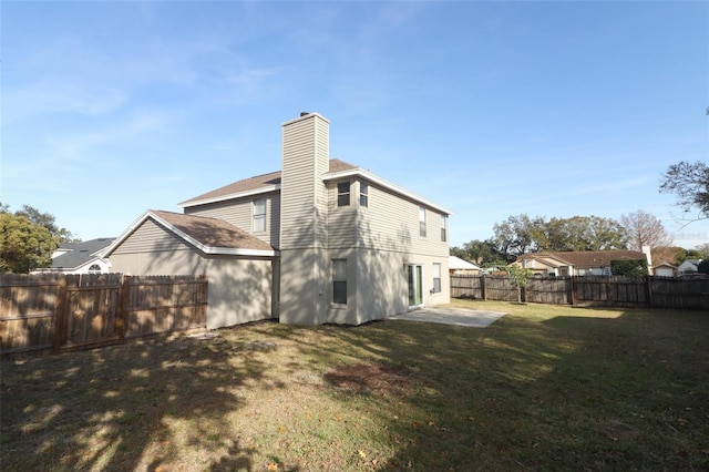 back of property with a patio area and a yard