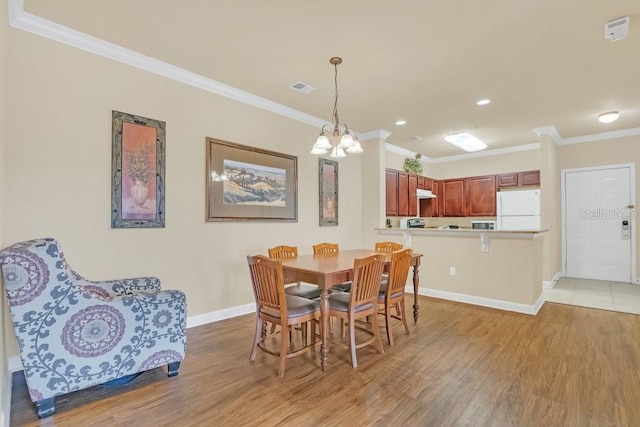 dining space featuring ornamental molding and light hardwood / wood-style floors