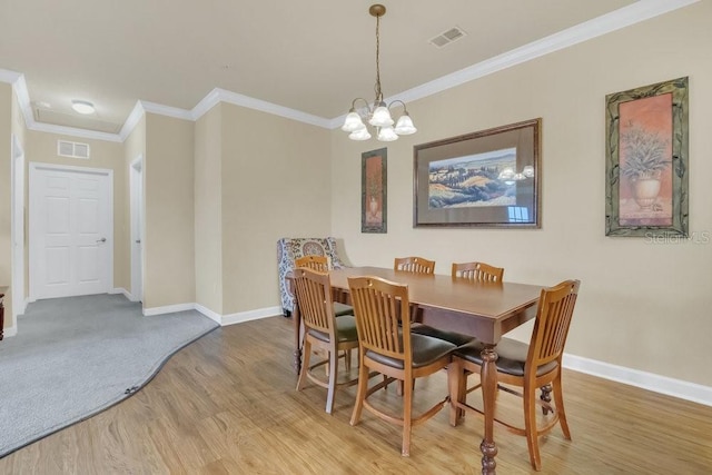 dining room with a notable chandelier, hardwood / wood-style flooring, and ornamental molding