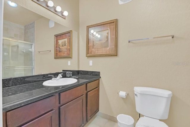 bathroom featuring vanity, tile patterned flooring, a shower with door, and toilet