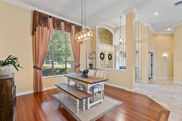 dining space featuring crown molding, hardwood / wood-style floors, and a chandelier