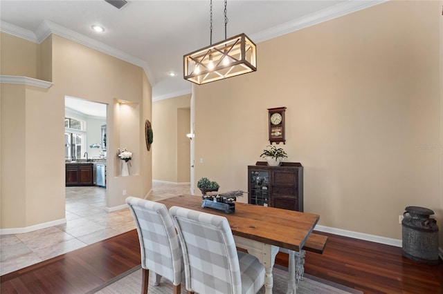 dining space featuring a notable chandelier, crown molding, and light wood-type flooring