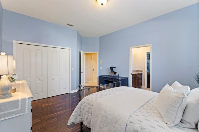 bedroom featuring dark wood-type flooring, connected bathroom, and a closet