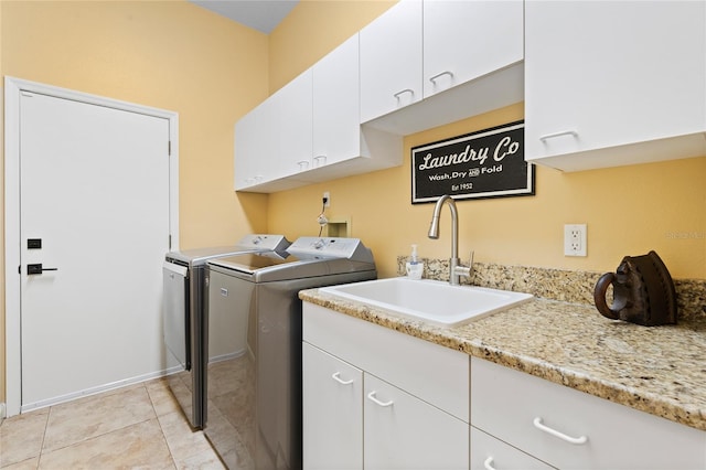 laundry area with cabinets, washing machine and dryer, sink, and light tile patterned floors